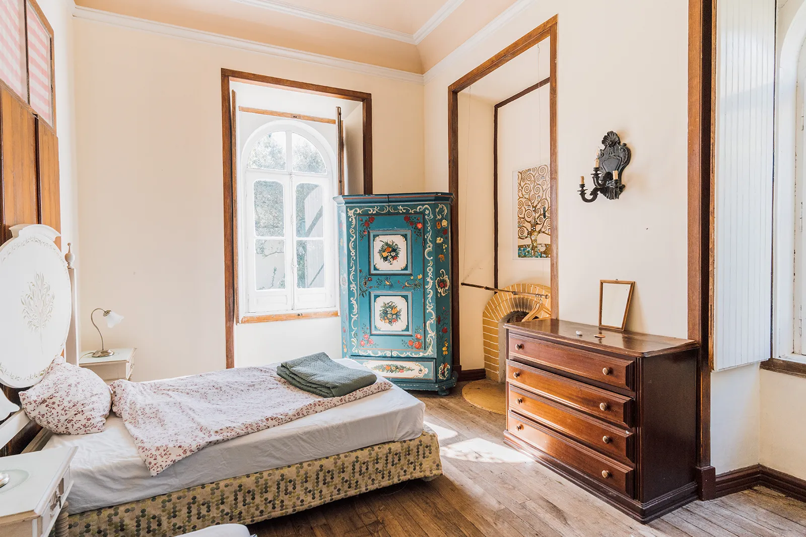 Helles Zimmer im Seminarhaus mit Bett, Kommode und Holzboden